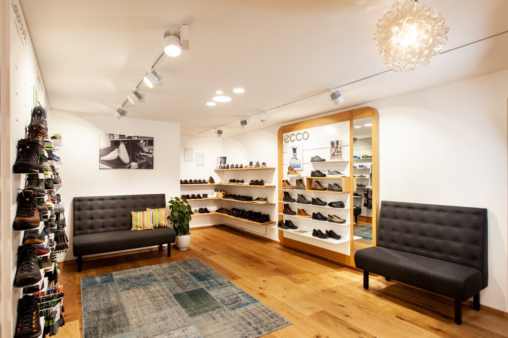 Otter Orthopädie & Schuhe - Schuhgeschäft von innen mit Sitzmöglichkeiten und Regalen mit Schuhen an der Wand.
